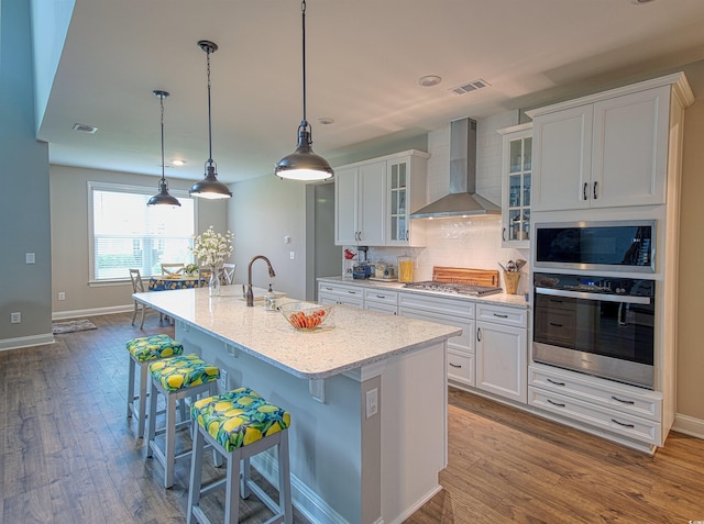376 Mikita Dr, Surfside Beach, SC 29575 - kitchen featuring appliances with stainless steel finishes, wall chimney range hood, dark wood-style floors, and a kitchen breakfast bar