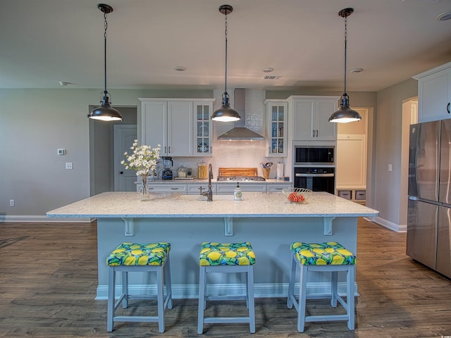 376 Mikita Dr, Surfside Beach, SC 29575 - kitchen with stainless steel appliances, wall chimney range hood, white cabinetry, dark wood finished floors, and a kitchen bar