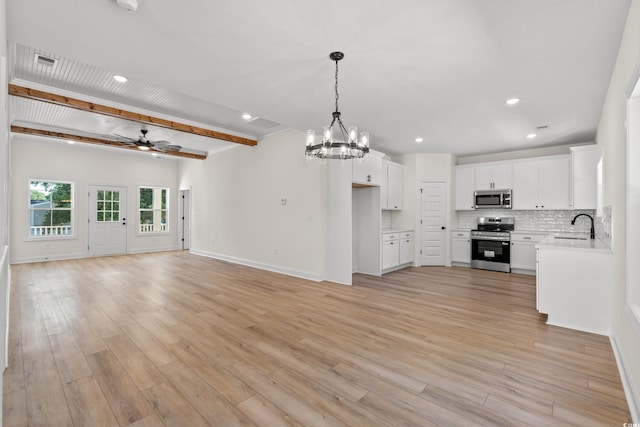 2428 Park St, North Myrtle Beach, SC 29582 - unfurnished living room with a chandelier, a ceiling fan, light wood-style flooring, recessed lighting, and beamed ceiling