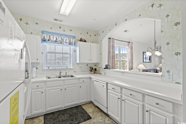 5801 Oyster Catcher Dr Unit 431, North Myrtle Beach, SC 29582 - kitchen featuring white appliances, wallpapered walls, white cabinetry, arched walkways, and light countertops
