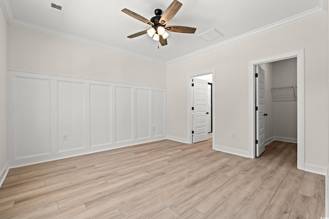 2426 Park St, North Myrtle Beach, SC 29582 - unfurnished bedroom featuring ornamental molding, light wood-type flooring, a closet, a spacious closet, and a decorative wall
