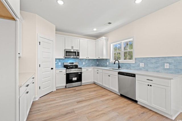 2426 Park St, North Myrtle Beach, SC 29582 - kitchen with appliances with stainless steel finishes, light countertops, white cabinets, decorative backsplash, and recessed lighting