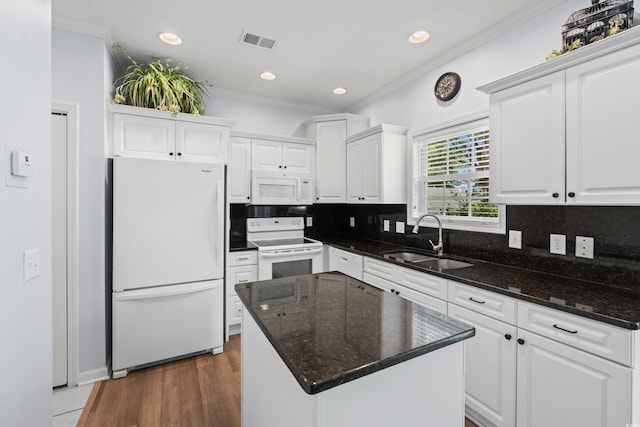 503 20th Ave N Unit 9D, North Myrtle Beach, SC 29582 - kitchen featuring white appliances, crown molding, white cabinets, decorative backsplash, and a kitchen island