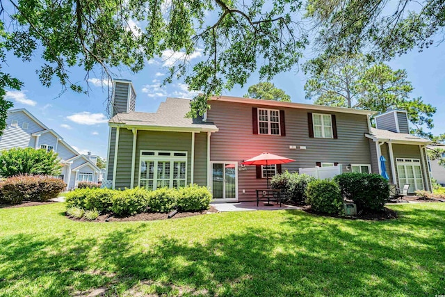 503 20th Ave N Unit 9D, North Myrtle Beach, SC 29582 - back of property with a chimney, a lawn, and a patio