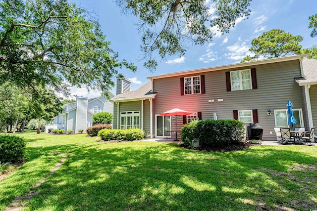 503 20th Ave N Unit 9D, North Myrtle Beach, SC 29582 - back of property with a patio, a lawn, and a chimney
