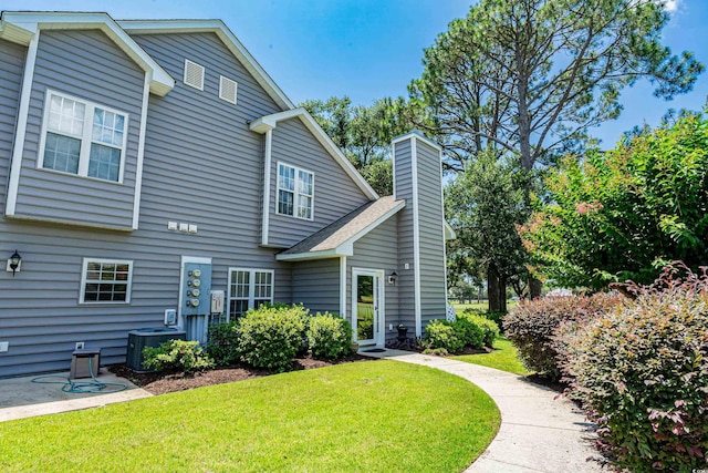 503 20th Ave N Unit 9D, North Myrtle Beach, SC 29582 - back of house with a yard and a chimney