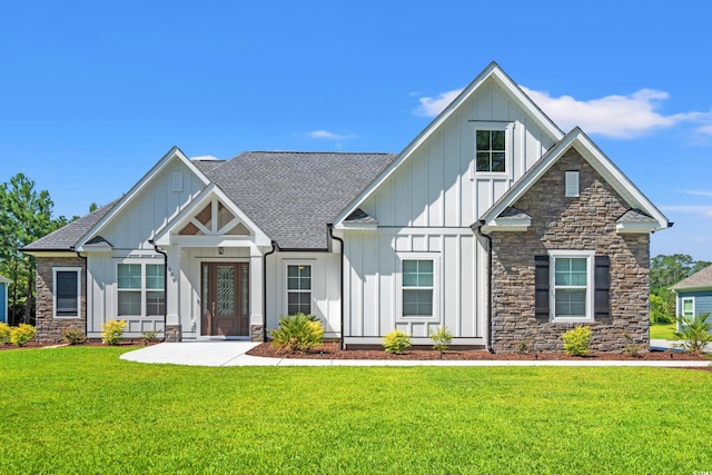 609 Mccown Dr, Conway, SC 29526 - view of front of property featuring board and batten siding, stone siding, a shingled roof, and a front lawn