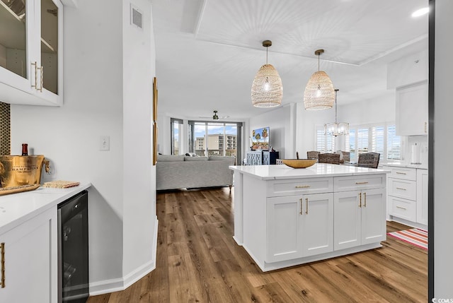 139 S Dunes Dr Unit 304, Pawleys Island, SC 29585 - kitchen featuring wine cooler, white cabinets, wood finished floors, open floor plan, and hanging light fixtures