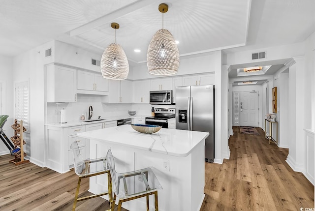 139 S Dunes Dr Unit 304, Pawleys Island, SC 29585 - kitchen with stainless steel appliances, light wood finished floors, and white cabinets