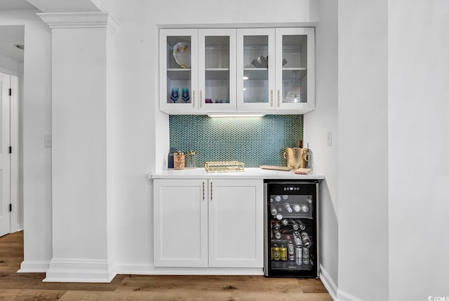139 S Dunes Dr Unit 304, Pawleys Island, SC 29585 - indoor wet bar featuring beverage cooler, decorative backsplash, and wood finished floors