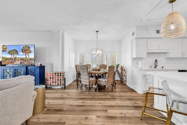 139 S Dunes Dr Unit 304, Pawleys Island, SC 29585 - dining area with light wood-style flooring and a chandelier