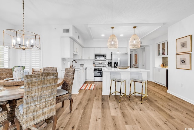 139 S Dunes Dr Unit 304, Pawleys Island, SC 29585 - kitchen featuring appliances with stainless steel finishes, a chandelier, white cabinetry, light wood-style floors, and light countertops
