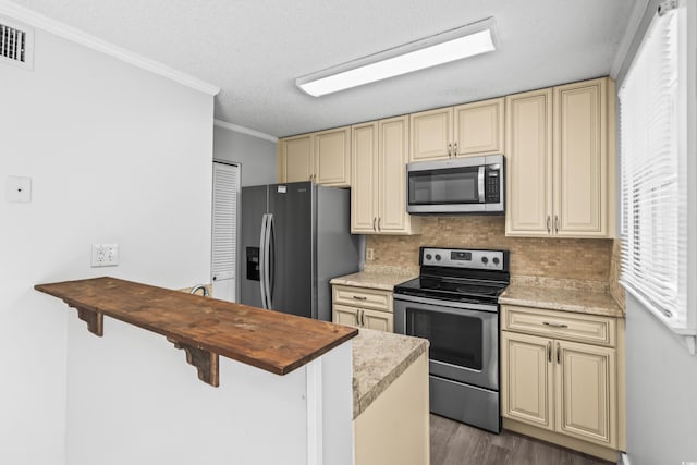 4115 Little River Rd Unit 1-E, Myrtle Beach, SC 29577 - kitchen with appliances with stainless steel finishes, cream cabinetry, wood counters, decorative backsplash, and crown molding