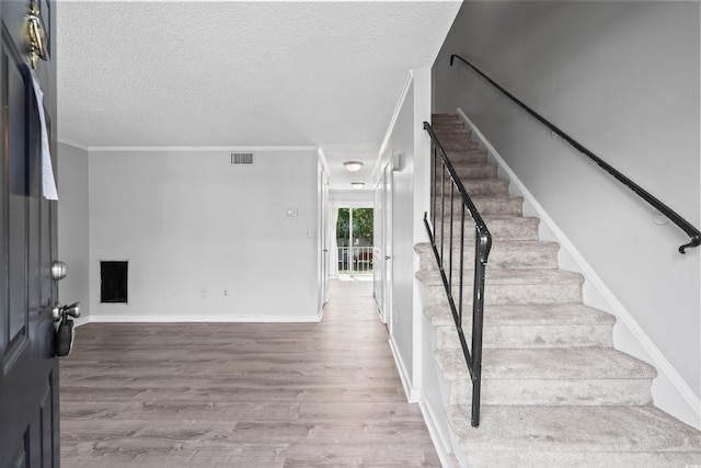 4115 Little River Rd Unit 1-E, Myrtle Beach, SC 29577 - staircase with wood finished floors, a textured ceiling, and ornamental molding