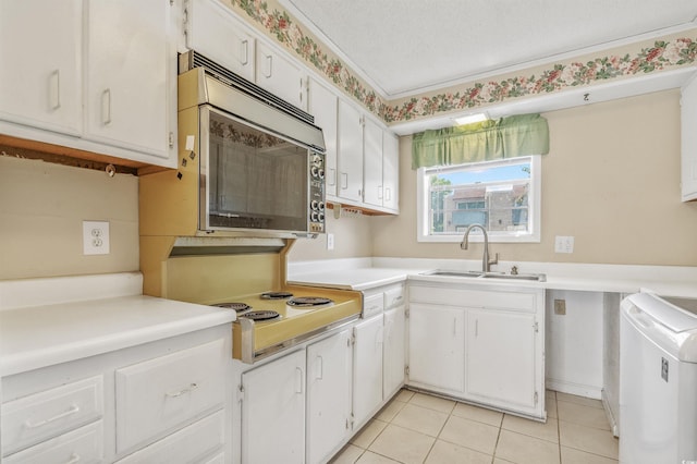 4701 N Kings Hwy Unit 8, Myrtle Beach, SC 29577 - kitchen featuring stainless steel microwave, electric cooktop, washer / clothes dryer, white cabinetry, and light tile patterned floors