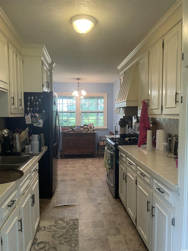 1872 Harris Short Cut Rd, Conway, SC 29526 - kitchen with stainless steel gas stove, tile counters, premium range hood, a chandelier, and decorative backsplash