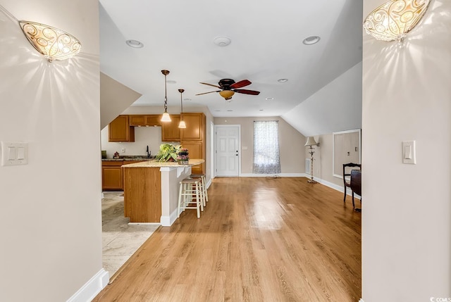 487 Trestle Way, Conway, SC 29526 - kitchen with a kitchen breakfast bar, brown cabinets, ceiling fan, light wood finished floors, and decorative light fixtures