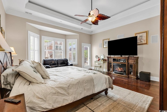 487 Trestle Way, Conway, SC 29526 - bedroom featuring a raised ceiling, wood finished floors, crown molding, a glass covered fireplace, and a ceiling fan
