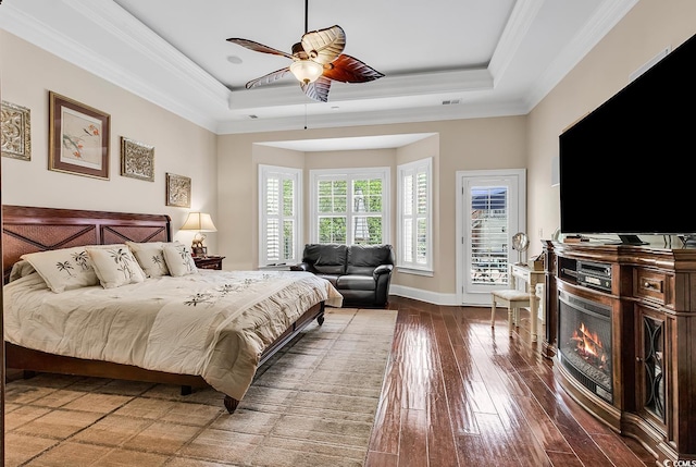 487 Trestle Way, Conway, SC 29526 - bedroom with a tray ceiling, a warm lit fireplace, hardwood / wood-style floors, access to outside, and crown molding