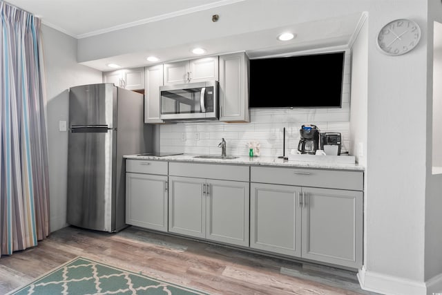 4800 S Ocean Blvd Unit 520, North Myrtle Beach, SC 29582 - bar area with appliances with stainless steel finishes, crown molding, backsplash, and light wood-style flooring