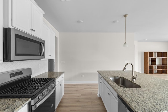 490 Calhoun Falls Dr, Myrtle Beach, SC 29579 - kitchen with appliances with stainless steel finishes, white cabinets, light wood-style floors, light stone countertops, and backsplash