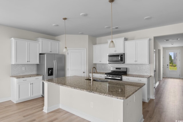 490 Calhoun Falls Dr, Myrtle Beach, SC 29579 - kitchen with stainless steel appliances, light wood finished floors, decorative backsplash, and white cabinetry