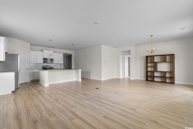 490 Calhoun Falls Dr, Myrtle Beach, SC 29579 - unfurnished living room with a chandelier and light wood-style flooring