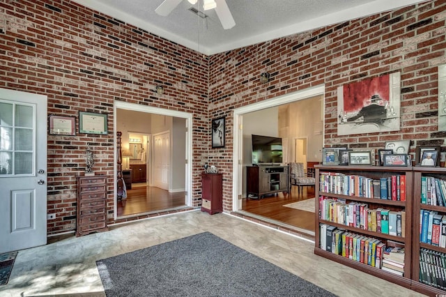 1010 Swan Lake Dr, North Myrtle Beach, SC 29582 - living area featuring ceiling fan, a textured ceiling, brick wall, and a towering ceiling