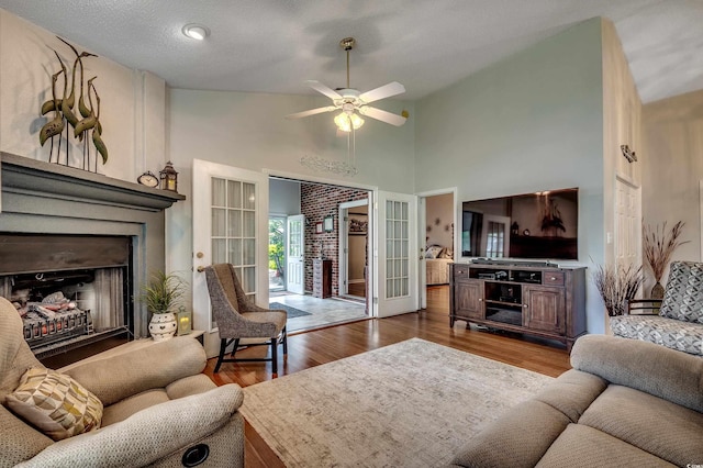1010 Swan Lake Dr, North Myrtle Beach, SC 29582 - living room with wood finished floors, a large fireplace, high vaulted ceiling, ceiling fan, and french doors
