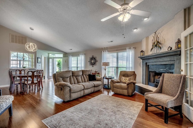 1010 Swan Lake Dr, North Myrtle Beach, SC 29582 - living room with a textured ceiling, vaulted ceiling, wood finished floors, a fireplace with raised hearth, and ceiling fan