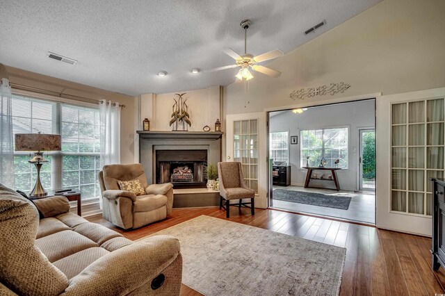 1010 Swan Lake Dr, North Myrtle Beach, SC 29582 - living area with a textured ceiling, a fireplace with raised hearth, hardwood / wood-style floors, plenty of natural light, and ceiling fan