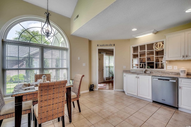 1010 Swan Lake Dr, North Myrtle Beach, SC 29582 - kitchen featuring stainless steel dishwasher, light tile patterned flooring, white cabinetry, hanging light fixtures, and light stone counters