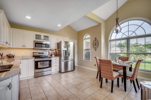 1010 Swan Lake Dr, North Myrtle Beach, SC 29582 - kitchen with stainless steel appliances, vaulted ceiling, white cabinetry, glass insert cabinets, and recessed lighting