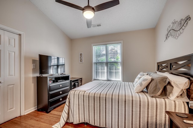 1010 Swan Lake Dr, North Myrtle Beach, SC 29582 - bedroom with light wood-style flooring, vaulted ceiling, a ceiling fan, and a textured ceiling