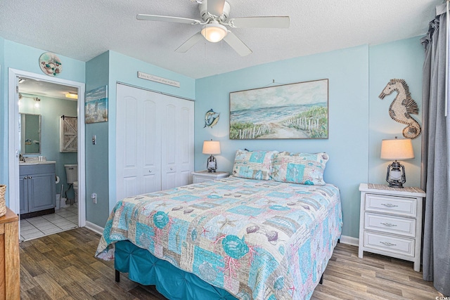 9400 Shore Dr Unit 716, Myrtle Beach, SC 29572 - bedroom with wood finished floors, a closet, a textured ceiling, ensuite bath, and ceiling fan