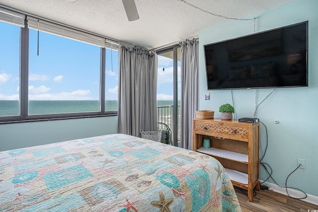9400 Shore Dr Unit 716, Myrtle Beach, SC 29572 - bedroom with wood finished floors, access to exterior, a textured ceiling, and ceiling fan