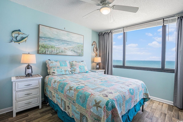 9400 Shore Dr Unit 716, Myrtle Beach, SC 29572 - bedroom with wood finished floors, a textured ceiling, a water view, and ceiling fan