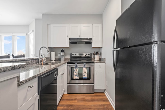 1100 Possum Trot Rd Unit F218, North Myrtle Beach, SC 29582 - kitchen with black appliances, under cabinet range hood, dark wood-style floors, white cabinetry, and light stone counters