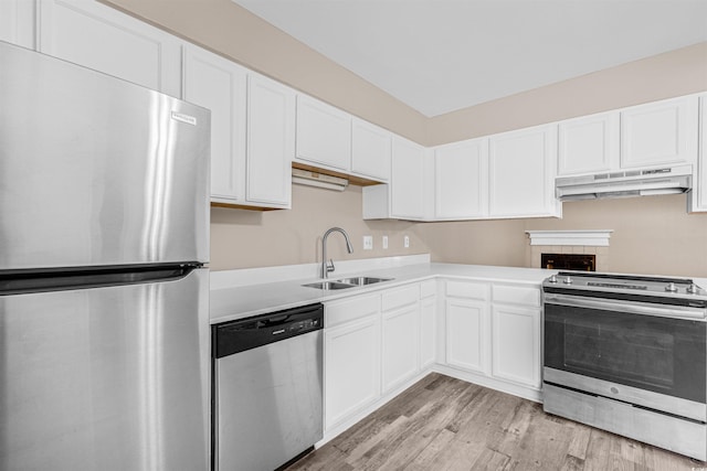 178 Beaver Pond Loop Unit 60, Pawleys Island, SC 29585 - kitchen with stainless steel appliances, under cabinet range hood, light countertops, light wood-style flooring, and white cabinets