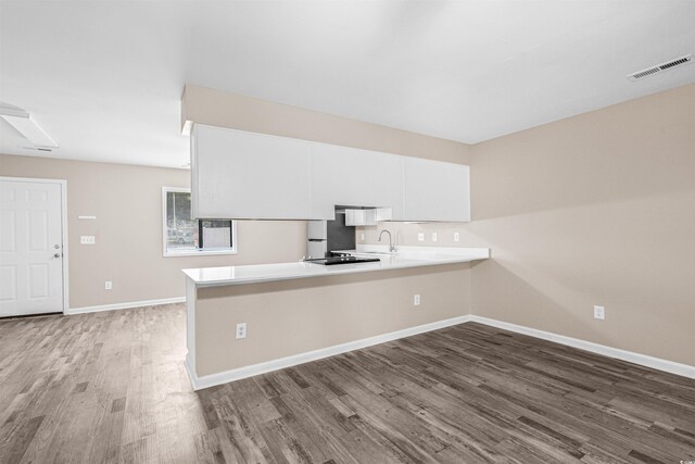 178 Beaver Pond Loop Unit 60, Pawleys Island, SC 29585 - kitchen with a peninsula, wood finished floors, light countertops, white cabinets, and fridge