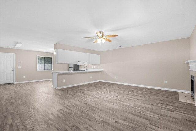 178 Beaver Pond Loop Unit 60, Pawleys Island, SC 29585 - unfurnished living room featuring a ceiling fan, wood finished floors, and a fireplace with flush hearth
