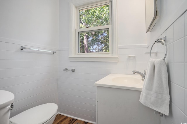 602 3rd Ave N, Myrtle Beach, SC 29577 - half bath with tile walls, a wainscoted wall, vanity, and wood finished floors