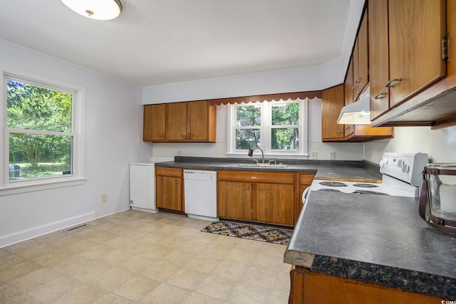 602 3rd Ave N, Myrtle Beach, SC 29577 - kitchen with white appliances, brown cabinets, dark countertops, under cabinet range hood, and ornamental molding