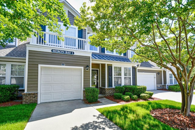 6172 Catalina Dr Unit 113, North Myrtle Beach, SC 29582 - view of front facade featuring driveway, brick siding, a standing seam roof, a metal roof, and roof with shingles