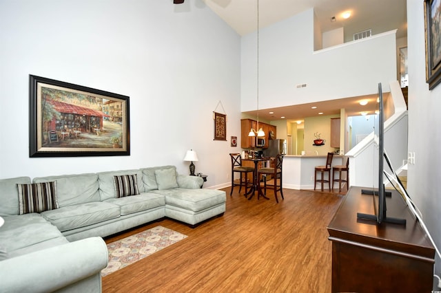 6172 Catalina Dr Unit 113, North Myrtle Beach, SC 29582 - living room with wood finished floors, ceiling fan, high vaulted ceiling, stairs, and a chandelier