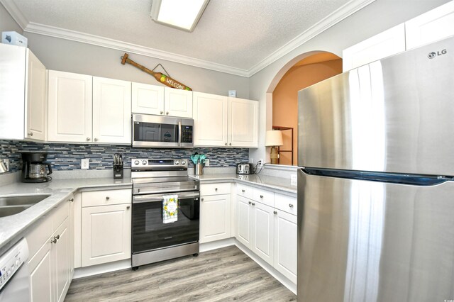 5825 Catalina Dr Unit 833, North Myrtle Beach, SC 29582 - kitchen with stainless steel appliances, ornamental molding, light countertops, white cabinets, and backsplash