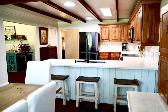 160 Comanche Dr, Georgetown, SC 29440 - kitchen with freestanding refrigerator, stainless steel microwave, beam ceiling, backsplash, and a peninsula
