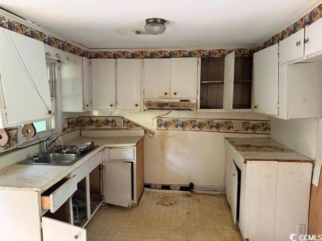 303 Leroy Bethea Rd, Mullins, SC 29574 - kitchen featuring light floors, range hood, white cabinetry, and light countertops