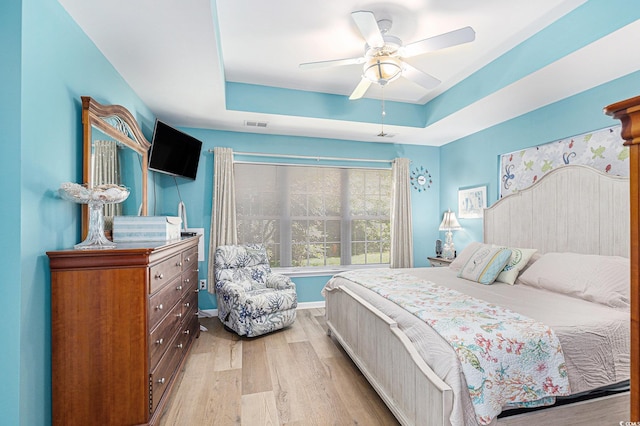 4610 Fringetree Dr, Murrells Inlet, SC 29576 - bedroom with light wood finished floors, a raised ceiling, and a ceiling fan