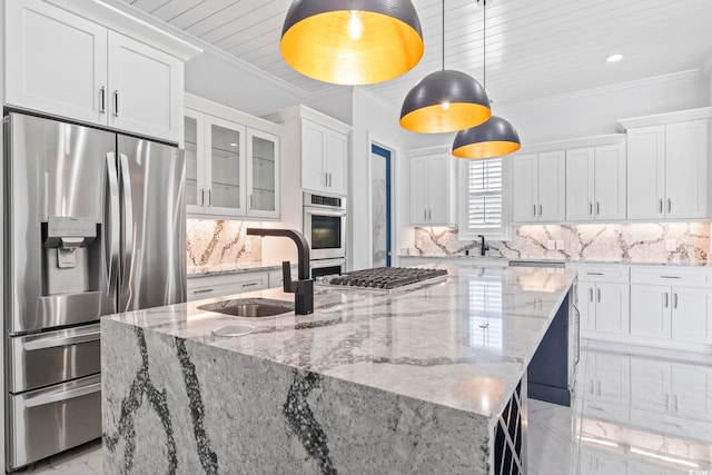 607 Boone Hall Dr, Myrtle Beach, SC 29579 - kitchen with appliances with stainless steel finishes, white cabinets, a center island with sink, light marble finish flooring, and tasteful backsplash